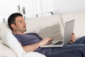 9611302-man-using-computer-on-sofa-at-home